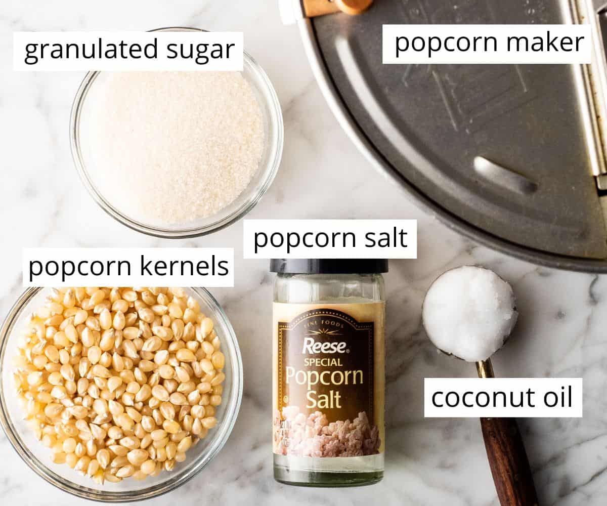 This easy homemade Kettle Corn Recipe is made with 4 ingredients, in less than 5 minutes on the stovetop. Better than the kettle corn at the fair! It's gluten-free and dairy-free! overhead view of the labeled ingredients in this homemade kettle corn recipe