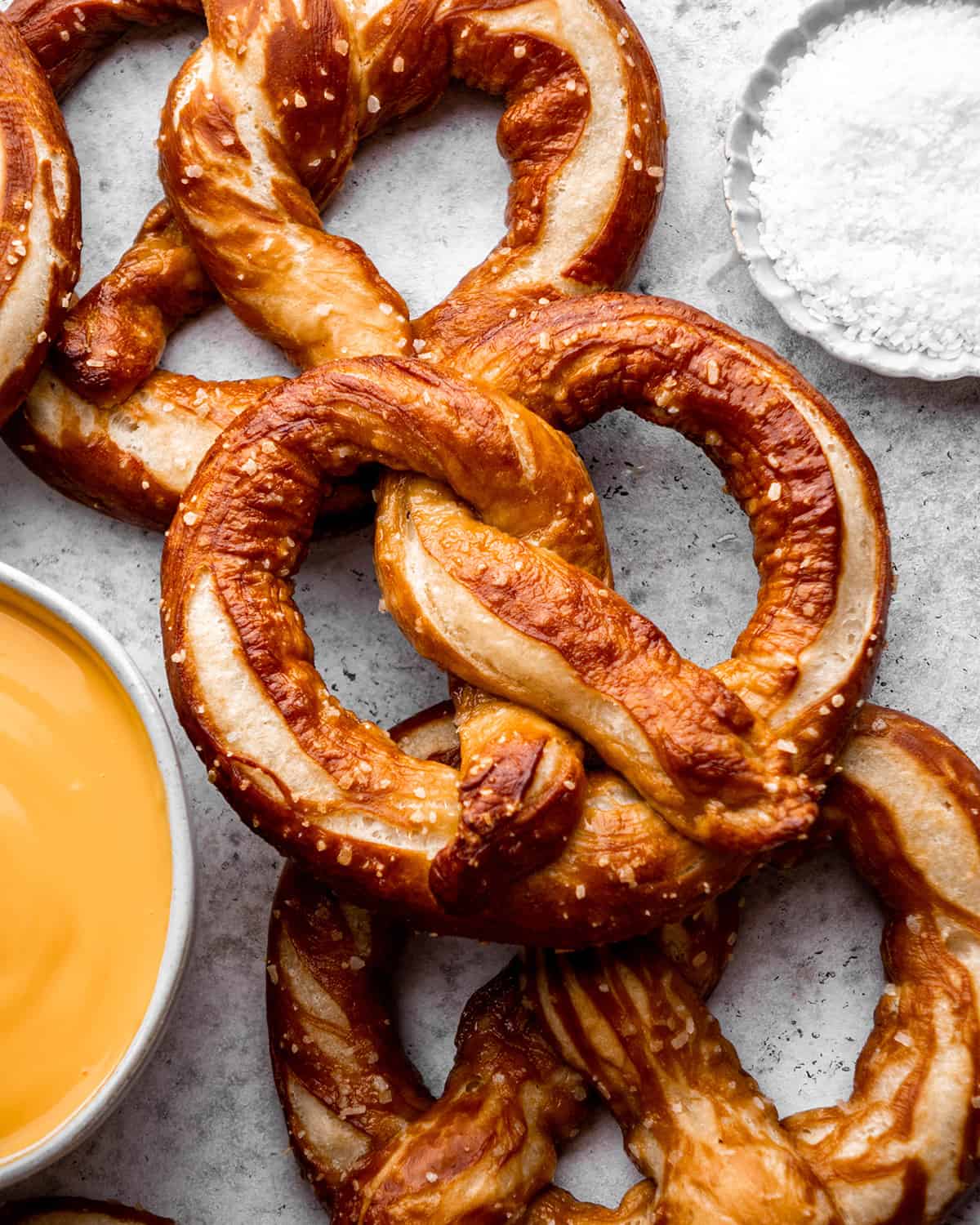 3 homemade soft pretzels with sea salt and cheese sauce on the side