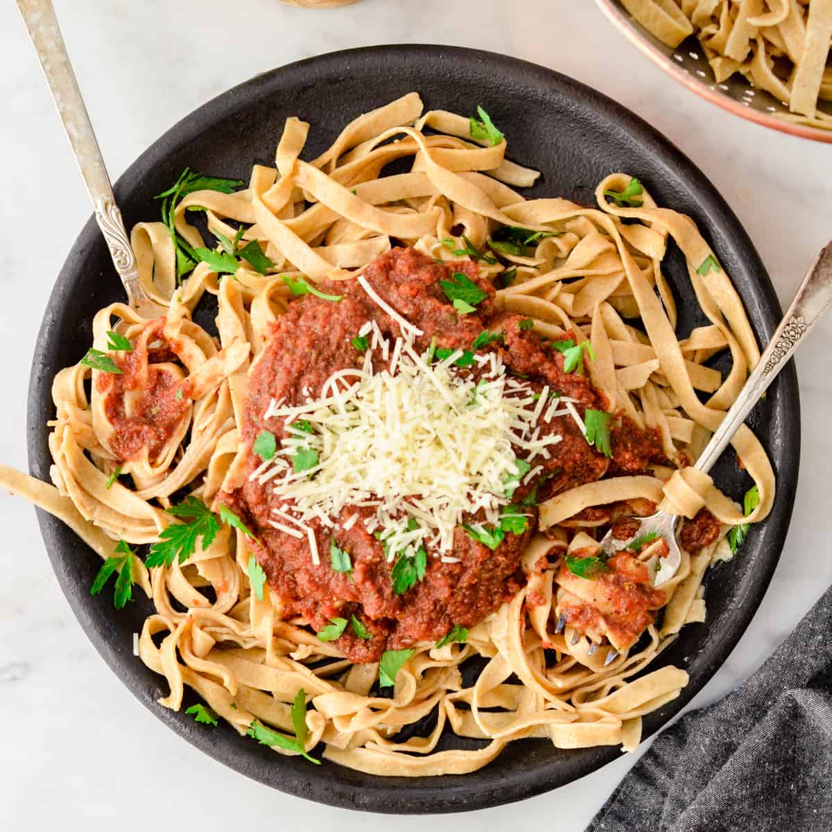 Homemade Whole Wheat Pasta topped with pasta sauce, parmesan cheese and fresh parsley.