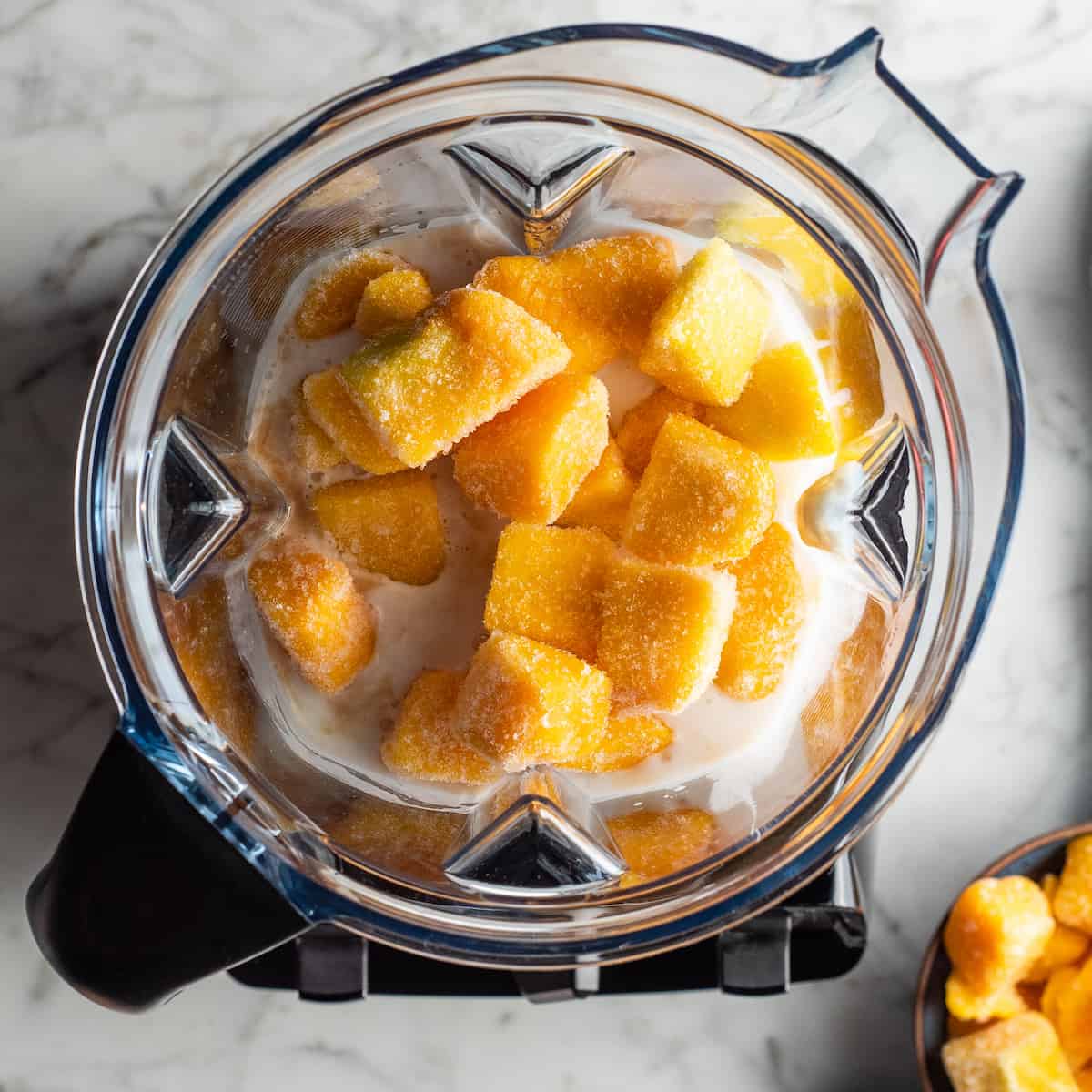 mango smoothie ingredients in a blender before blending