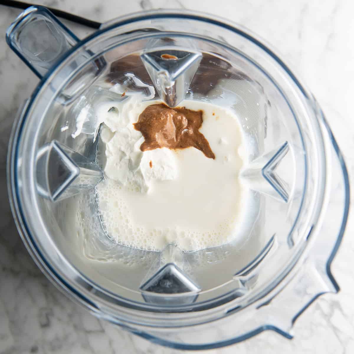 How to Make a Protein Smoothie - adding milk, yogurt and almond butter to the blending contianer