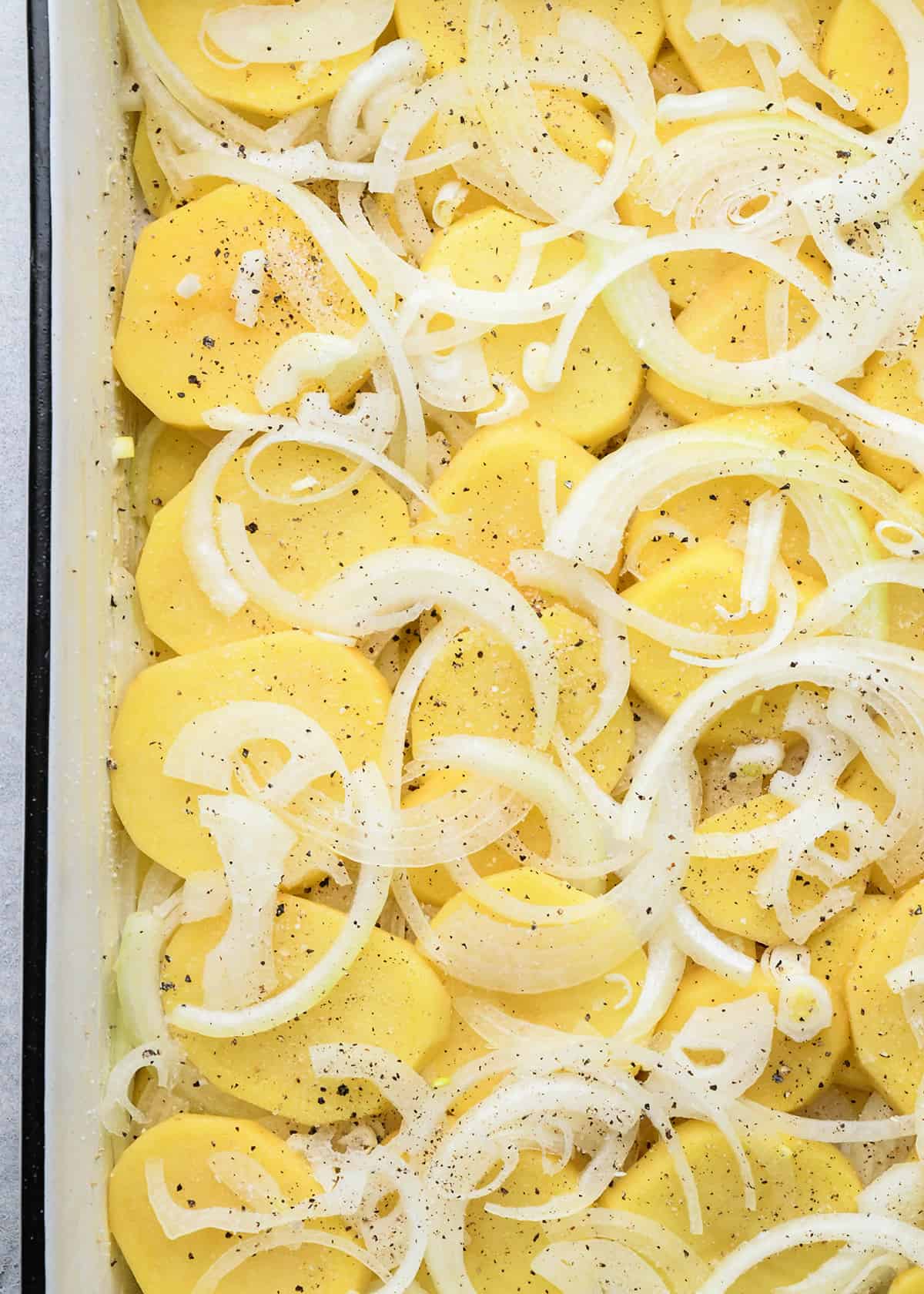 assembling au gratin potatoes in a baking dish
