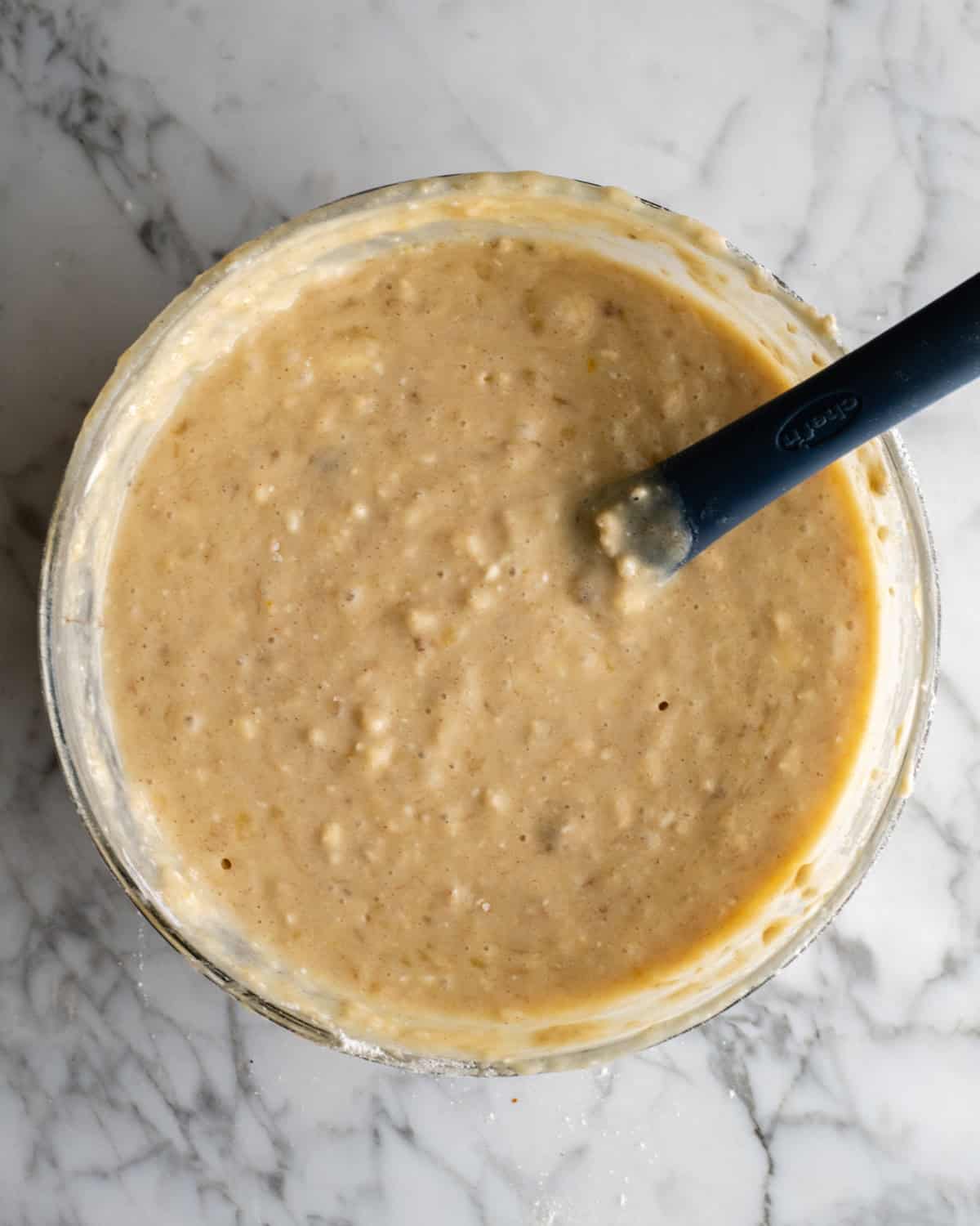How to Make Banana Cake - final batter in a glass bowl with a spatula