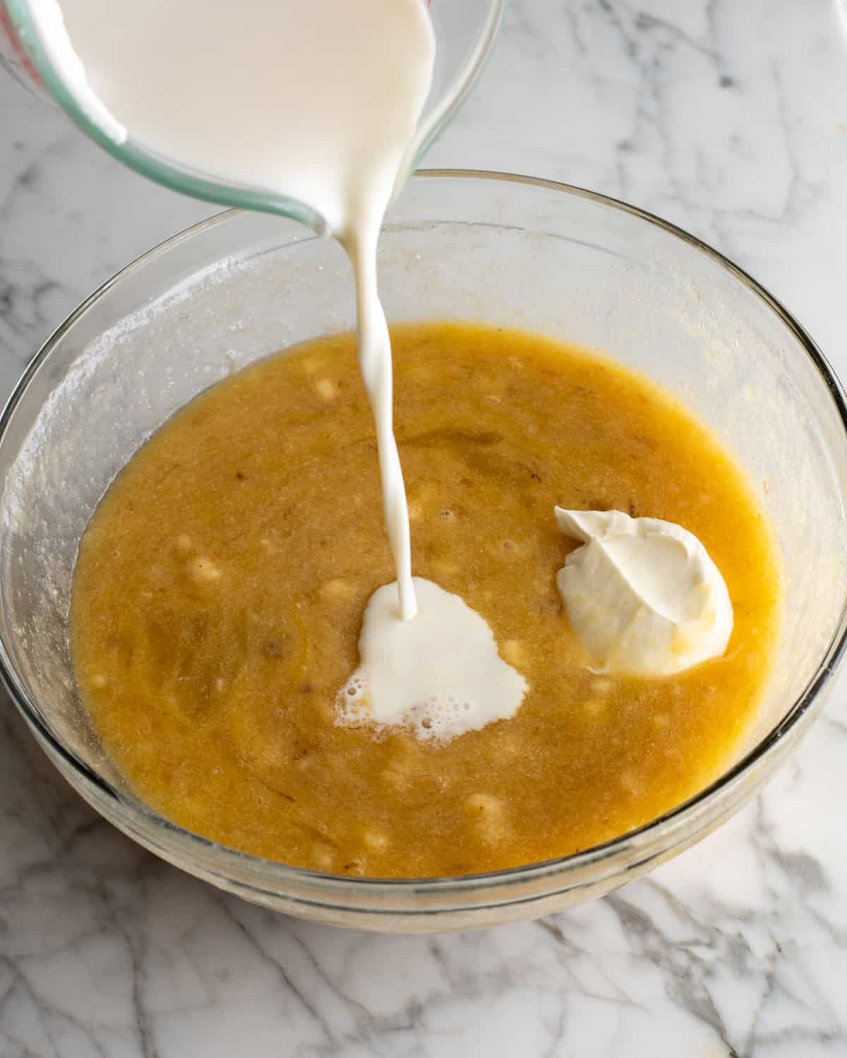 How to Make Banana Cake - sour cream added and milk being poured into the batter