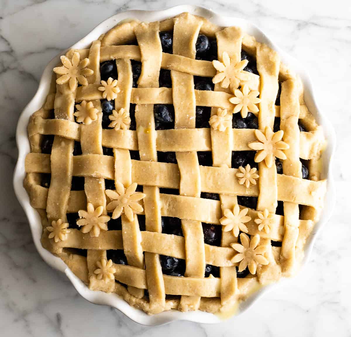 This is the best homemade Blueberry Pie Recipe you'll ever make! It's made from scratch with a fresh blueberry pie filling and NO cornstarch, and includes step-by-step instructions and photos! overhead view of a blueberry pie before baking