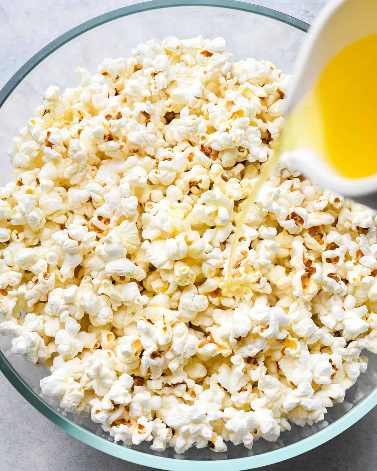 butter being poured over popped popcorn kernels to make Butter Popcorn