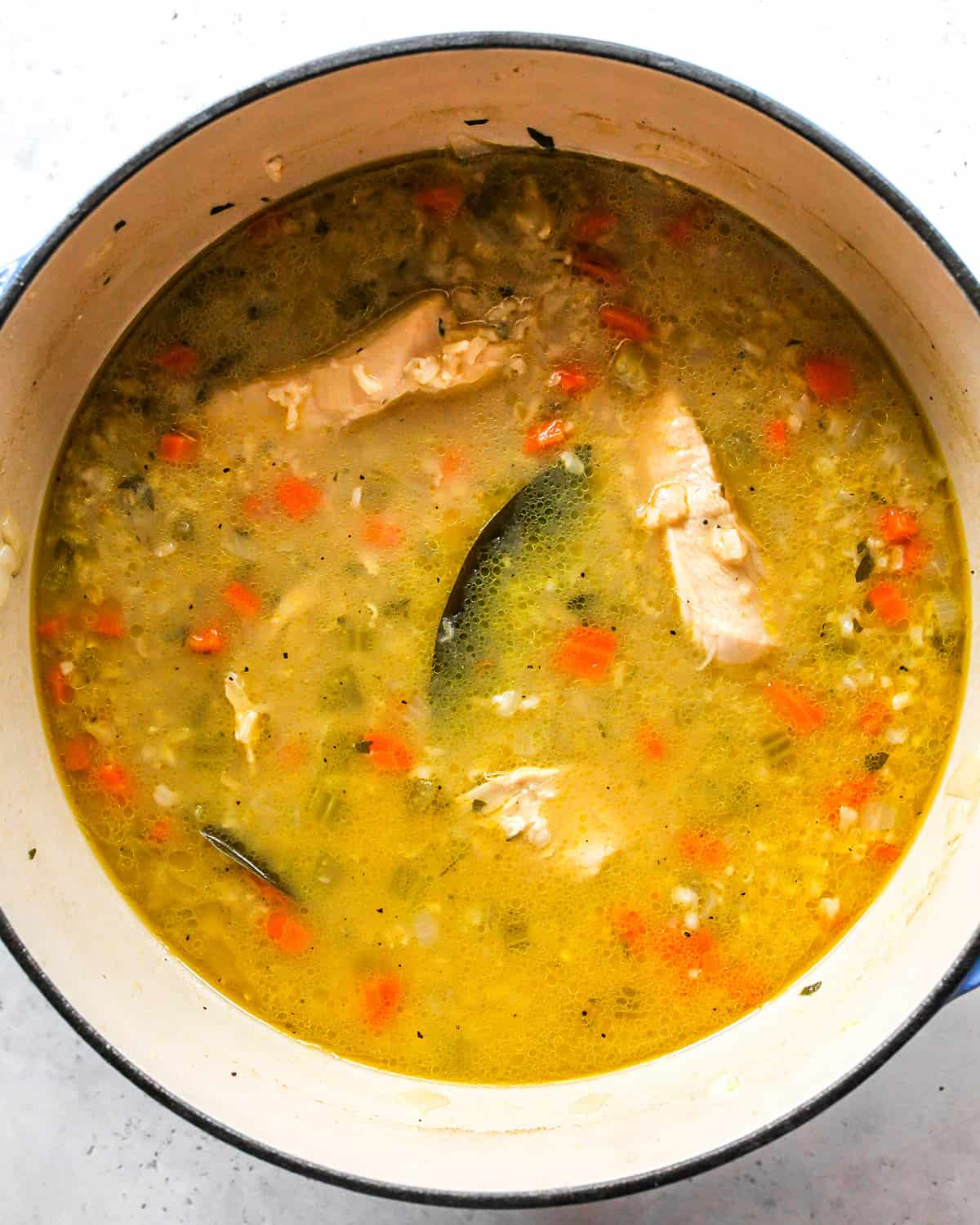 This Chicken and Rice Soup is flavorful, hearty, healthy and it's made in one pot in under an hour! Chicken and wild rice soup is a perfect meal for busy, chilly nights, it makes great leftovers & freezes well too! how to make Chicken Rice Soup - after cooking chicken