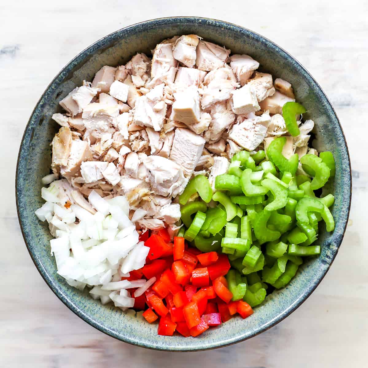 This Chicken Salad Recipe is easy to make with only a handful of simple ingredients. Serve as chicken salad sandwiches or on top of a bed of greens for a delicious, flavorful and light summertime meal! Watch the video and follow our step-by-step instructions to learn how to make chicken salad at home! overhead photo showing how to make chicken salad