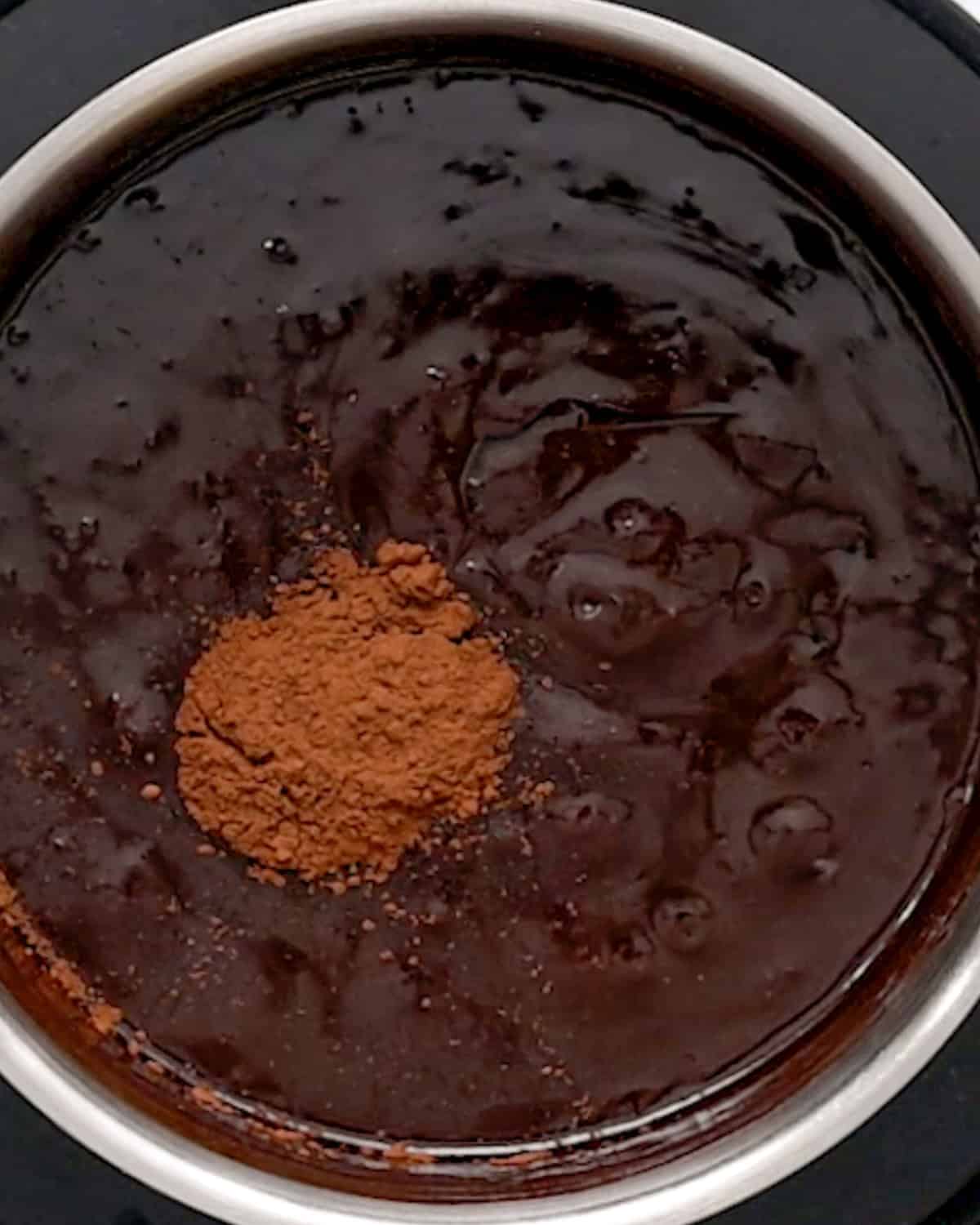 making Chocolate Peanut Butter Fondue in a pot- adding cocoa powder and vanilla