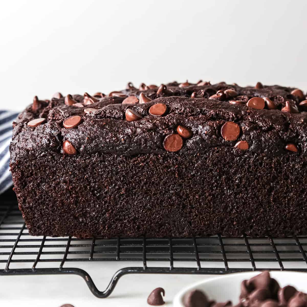 side view of a loaf of Healthy Chocolate Banana Bread cooling on a wire cooling rack
