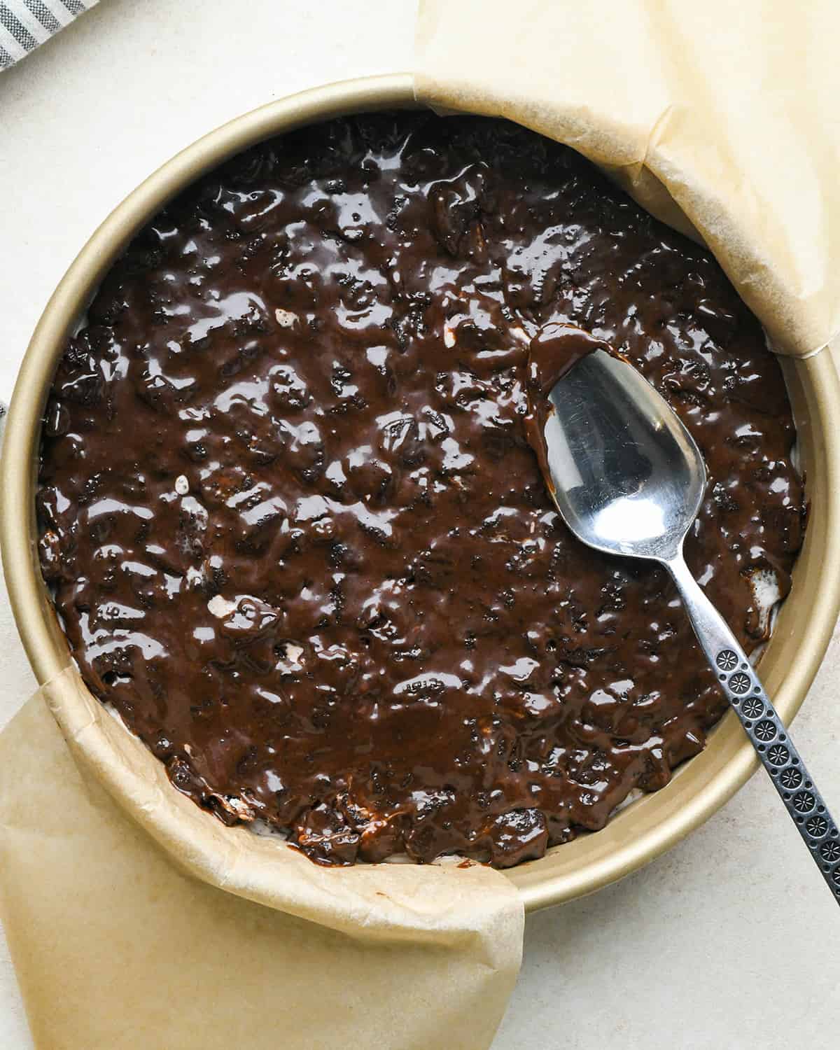 assembling an ice cream cake - oreo fudge sauce on top of ice cream layer after spreading out