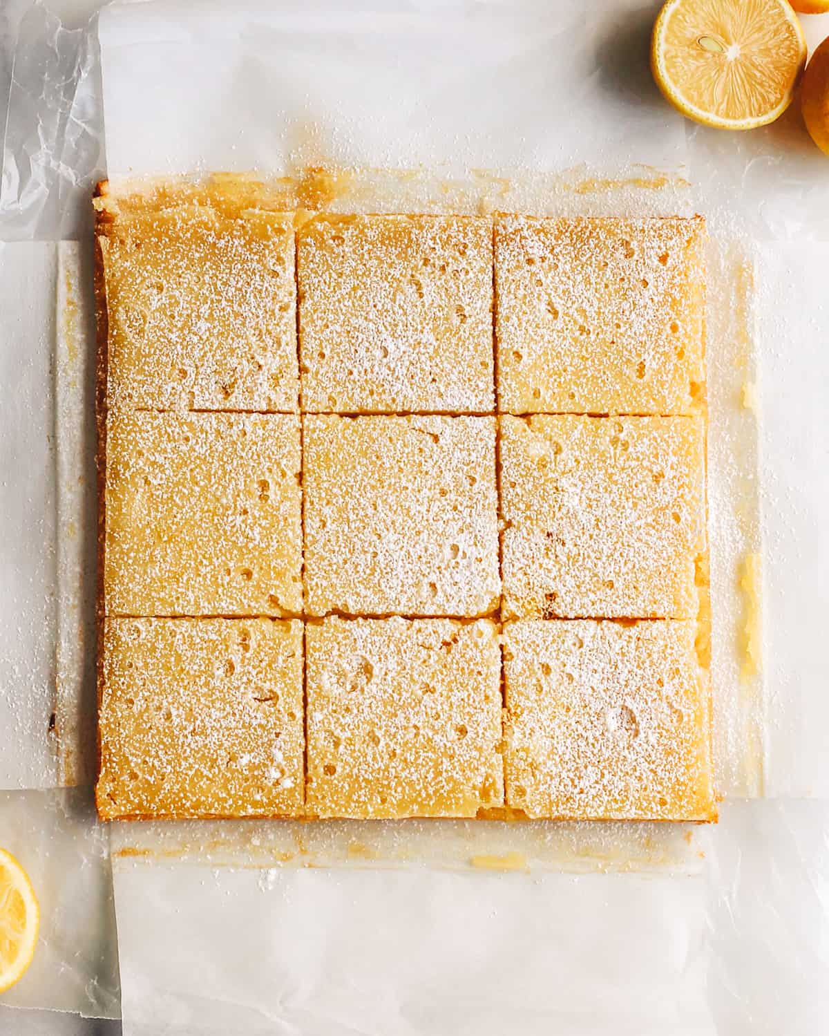 The best lemon bars! A smooth & sweet lemon filling sits on top of a buttery shortbread crust for the most delicious lemon squares recipe. Plus these easy lemon bars are simple to make with only 8 ingredients! overhead photo of 9 baked lemon squares