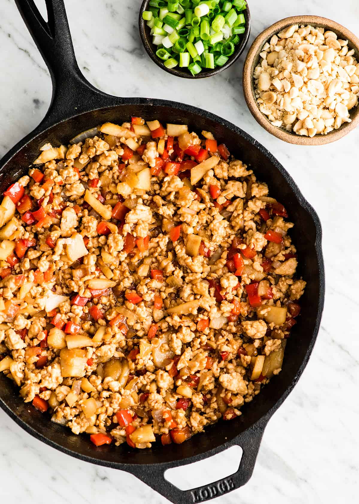 Asian Chicken Lettuce Wraps (better than P.F. Chang's)! A quick, easy, healthy and delicious dinner or appetizer! These lettuce wraps are our favorite! Step-by-step recipe video! #lettucewraps #pfchangs #glutenfree #dairyfree #easydinner #healthyrecipe #asianlettucewraps chicken lettuce wrap filling in a skillet