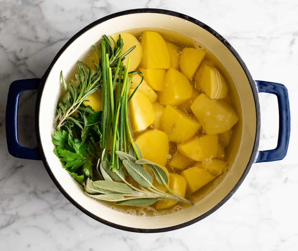 These herb-infused garlic mashed potatoes are the best mashed potatoes you will ever eat. They are creamy, fluffy buttery and so insanely delicious you will never make another mashed potatoes recipe again. Plus they're easy to make and can be prepared ahead of time! photo showing how to boil potatoes for mashed potatoes