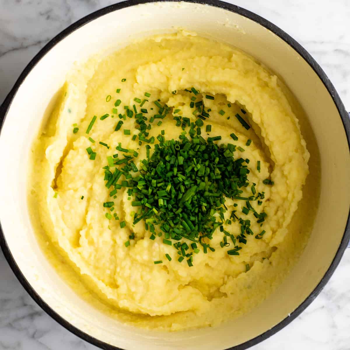 These herb-infused garlic mashed potatoes are the best mashed potatoes you will ever eat. They are creamy, fluffy buttery and so insanely delicious you will never make another mashed potatoes recipe again. Plus they're easy to make and can be prepared ahead of time! how to make mashed potatoes - adding chives