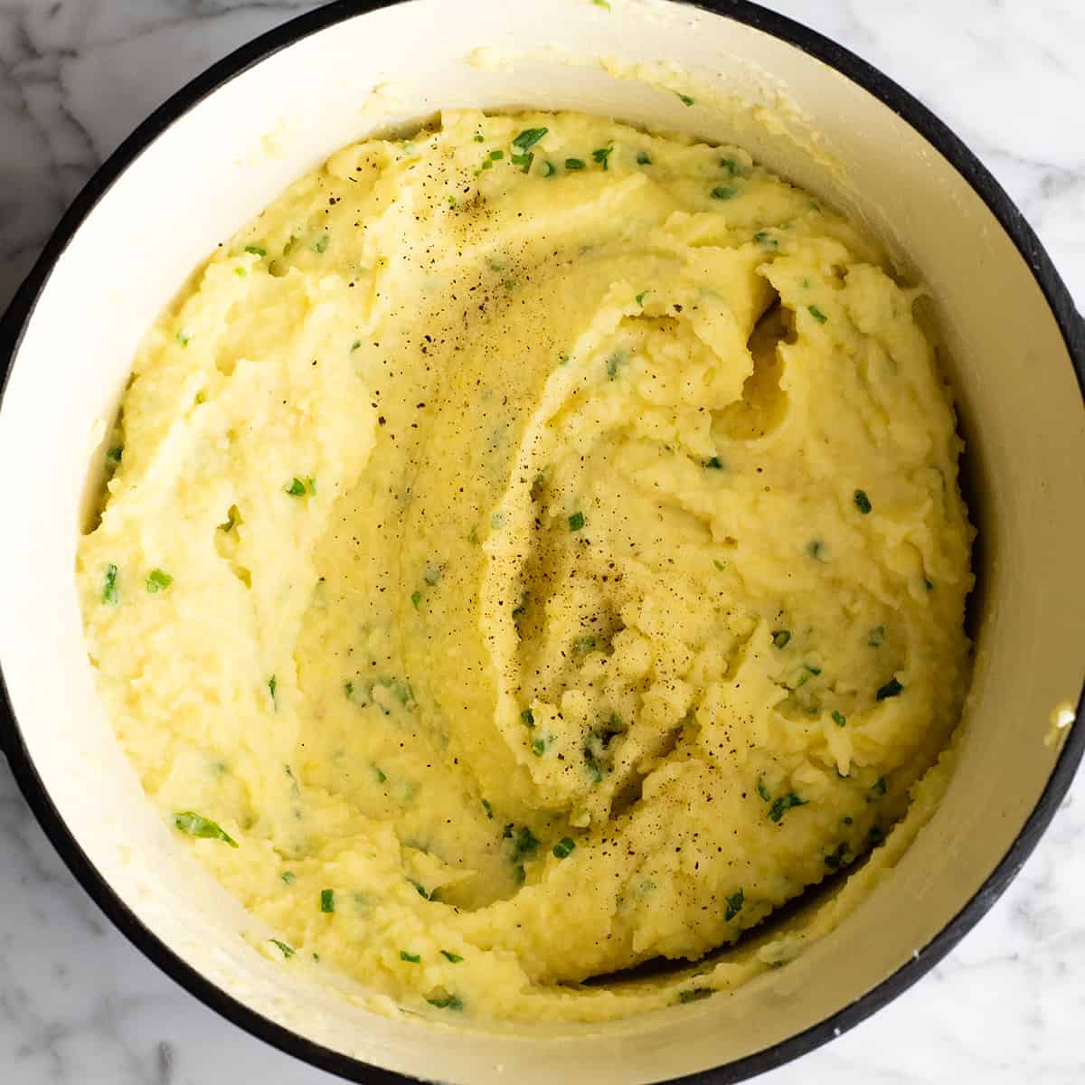 These herb-infused garlic mashed potatoes are the best mashed potatoes you will ever eat. They are creamy, fluffy buttery and so insanely delicious you will never make another mashed potatoes recipe again. Plus they're easy to make and can be prepared ahead of time! how to make mashed potatoes - adding extra salt and pepper