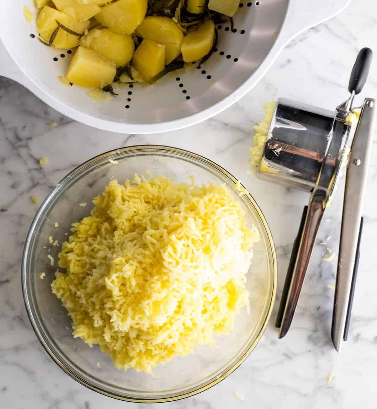 These herb-infused garlic mashed potatoes are the best mashed potatoes you will ever eat. They are creamy, fluffy buttery and so insanely delicious you will never make another mashed potatoes recipe again. Plus they're easy to make and can be prepared ahead of time! photo showing how to rice potatoes to make fluffy mashed potatoes