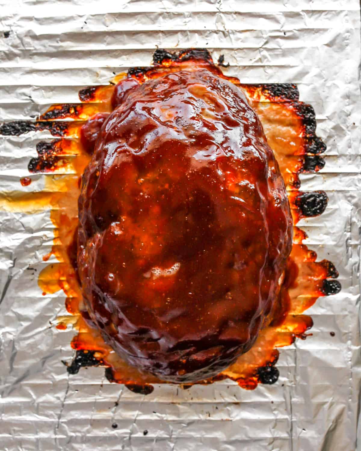This is the best meatloaf recipe ever! It’s tender, moist and flavorful with the most delicious glaze. This easy meatloaf recipe is a classic that your whole family will love! Watch the video and follow our step-by-step instructions to learn how to make meatloaf! baked meatloaf on a baking rack after broiling to make the glaze thicken