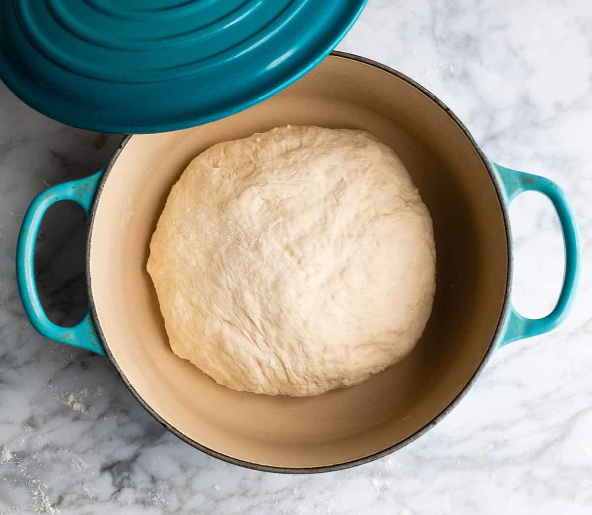 Easy Dutch Oven No Knead Bread recipe is made with only 4 ingredients and takes 5 minutes of prep time! If you want to make delicious homemade bread that looks & tastes like it came from a fancy bakery but actually takes very little effort, this dutch oven bread recipe is for you! overhead photo showing how to make dutch oven bread dough before baking in dutch oven