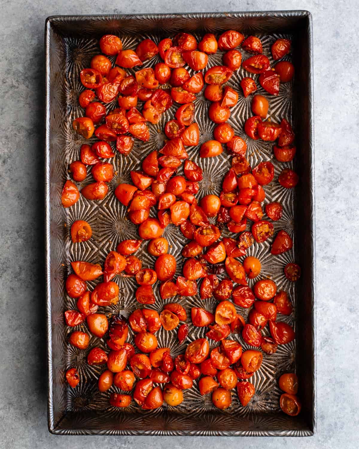 This Best Pasta Salad Recipe is made with Homemade Dressing & Roasted Tomatoes! It is the perfect healthy & flavorful make-ahead BBQ side dish full of fresh veggies, pepperoni and fresh mozzarella cheese! #pastasalad #bbq #sidedish #bestpastasalad #pastasaladrecipe #recipe #healthyrecipe #easypastasalad #homemadedressing How to Make Pasta Salad - tomatoes on a baking sheet before roasting