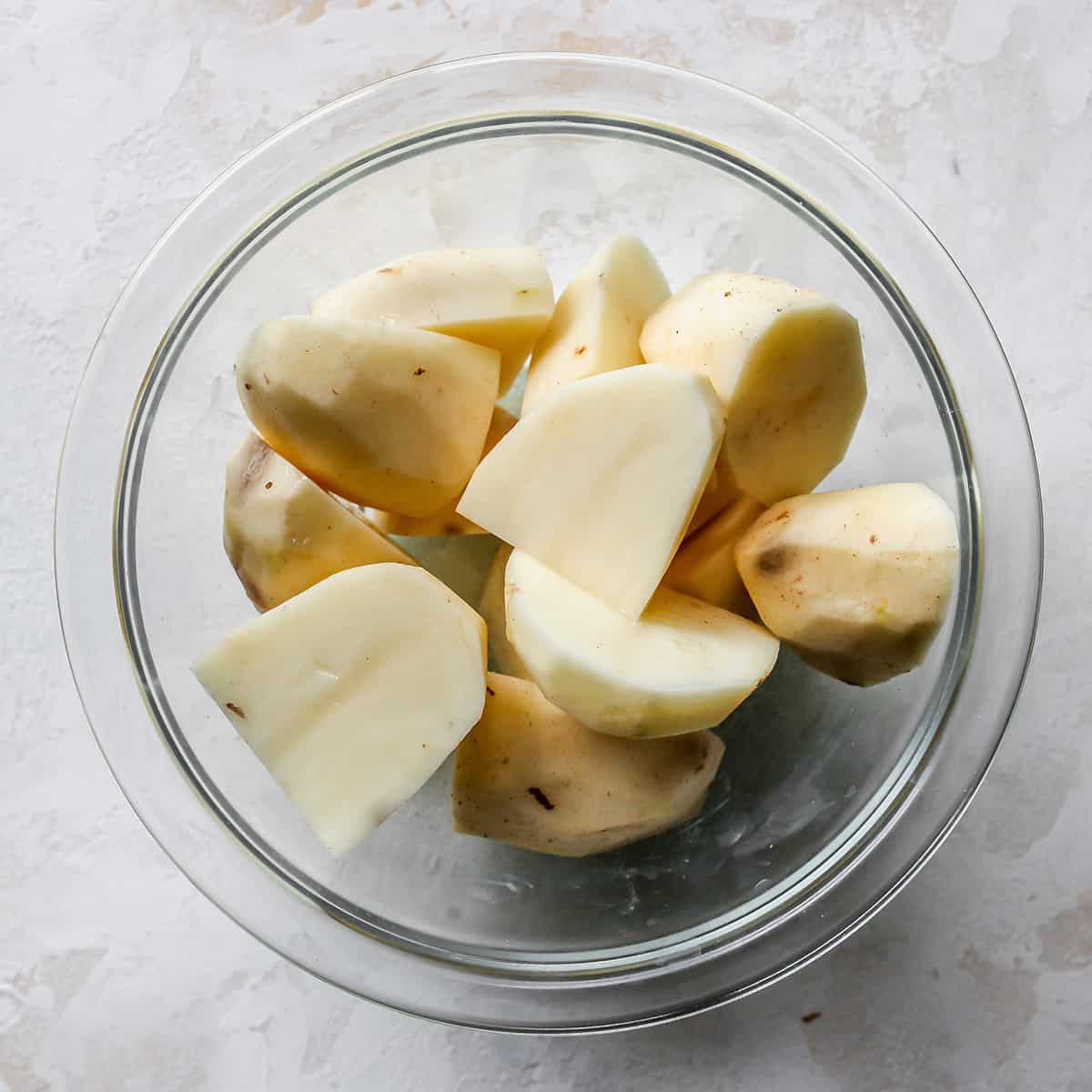 How To Make Potato Pancakes - potatoes peeled and cut in a bowl