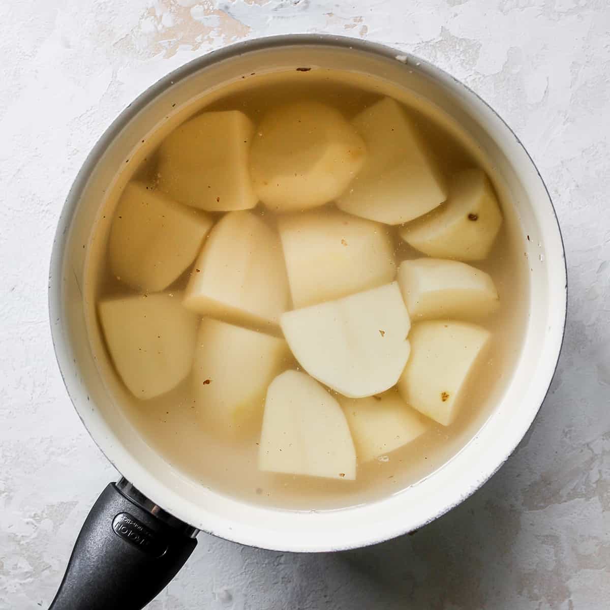 How To Make Potato Pancakes - potatoes cooking in water in a pot