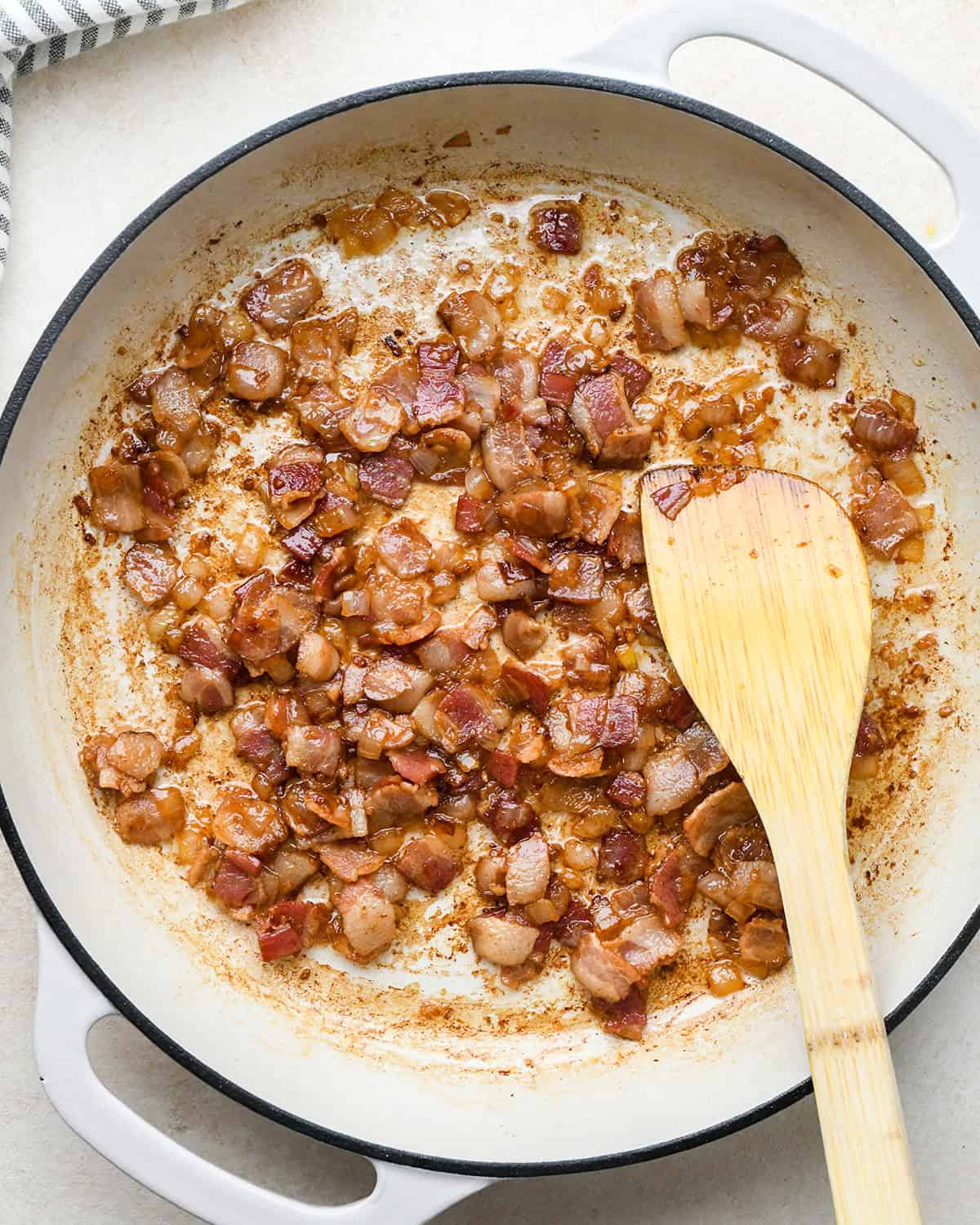 bacon, onion and garlic in a pan after cooking to make bacon quiche