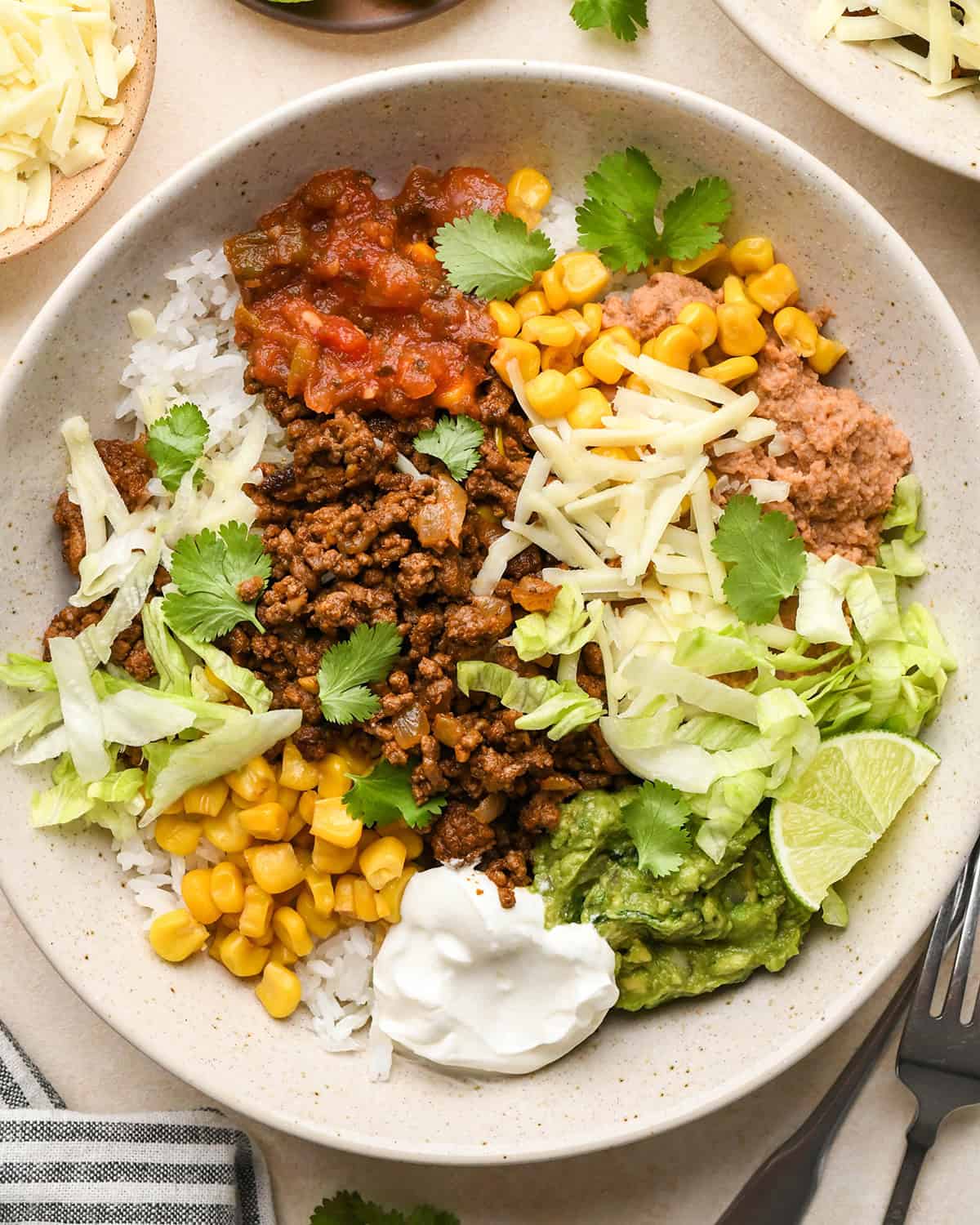 an assembled taco bowl with cilantro and lime
