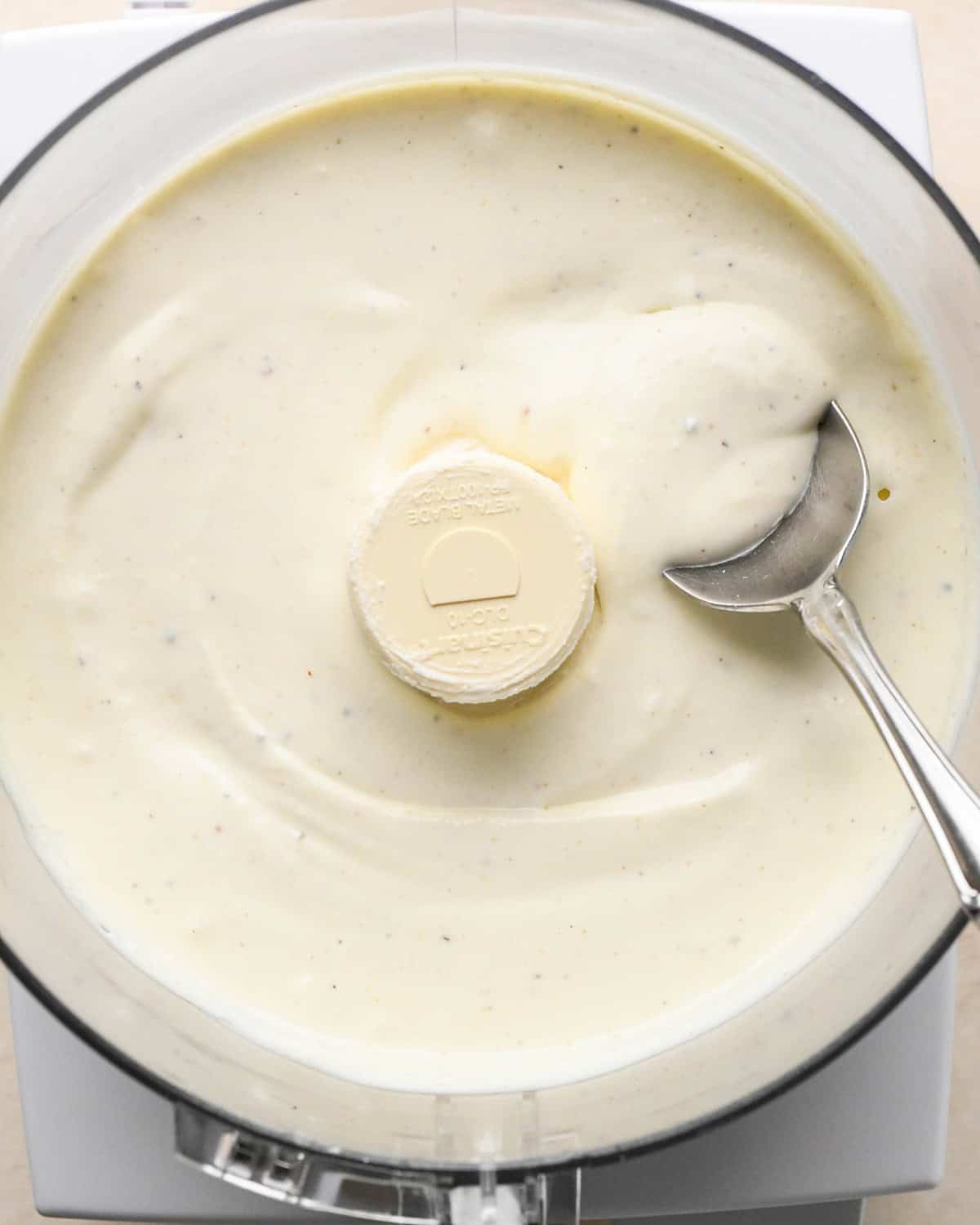 final Whipped Feta Cheese Dip in a food processor with a spoon
