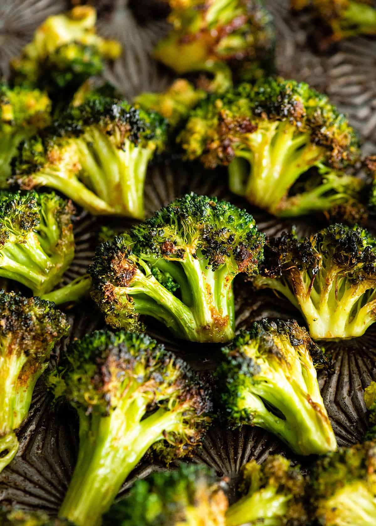 This is the best oven-roasted broccoli recipe! This easy roasted broccoli is made with 6 ingredients in 15 minutes! It's crispy, tender and perfectly seasoned! Baked broccoli is a healthy side dish that pairs well with everything! #broccoli #broccolirecipes #healthysidedish #sidedish #roastedbroccoli #joyfoodsunshine how to roast broccoli in the oven - broccoli on a baking sheet after roasting