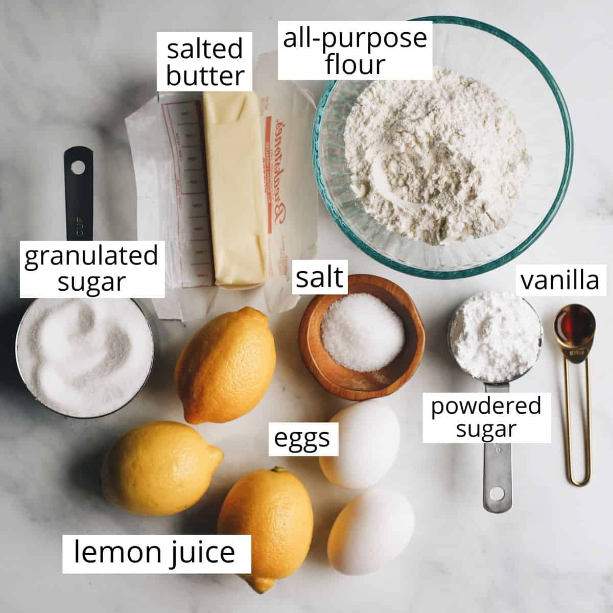 The best lemon bars! A smooth & sweet lemon filling sits on top of a buttery shortbread crust for the most delicious lemon squares recipe. Plus these easy lemon bars are simple to make with only 8 ingredients! overhead photo of the labeled ingredients in this Lemon Bars Recipe