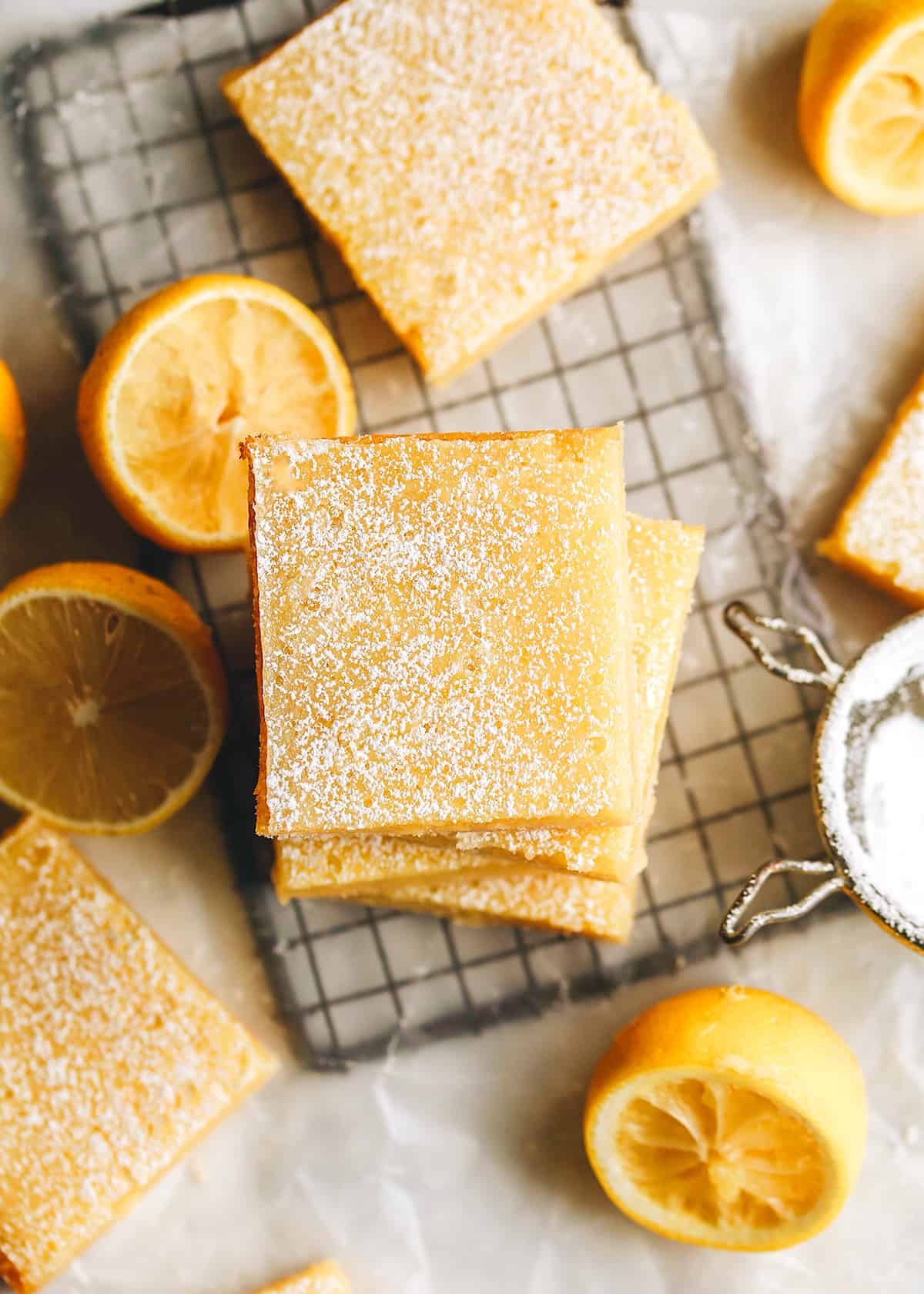 The best lemon bars! A smooth & sweet lemon filling sits on top of a buttery shortbread crust for the most delicious lemon squares recipe. Plus these easy lemon bars are simple to make with only 8 ingredients! overhead photo of 5 lemon bars