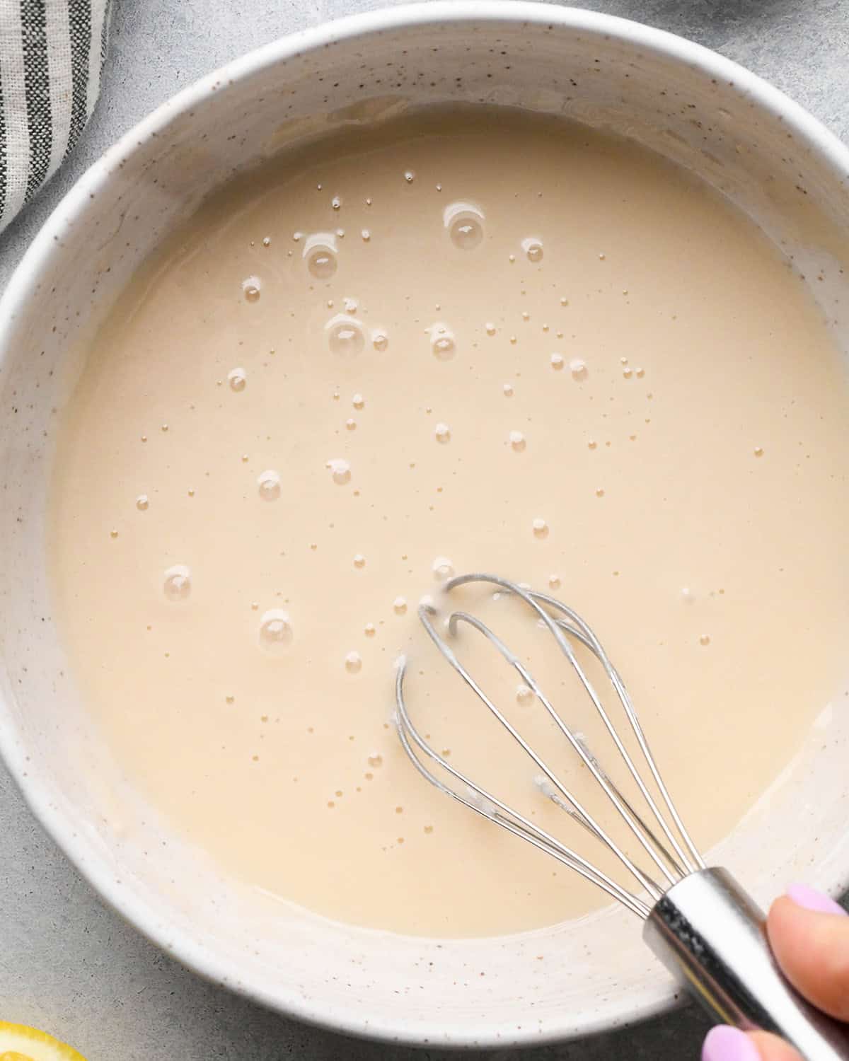 Lemon Poppy Seed Muffins glaze in a bowl with a whisk