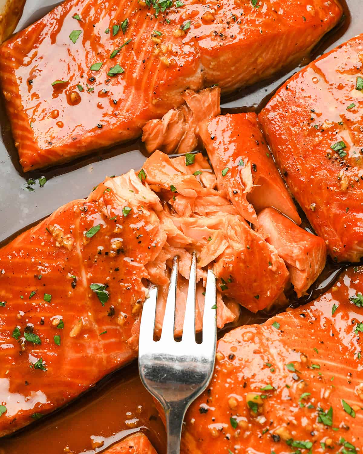 a fork taking a bite of maple glazed salmon