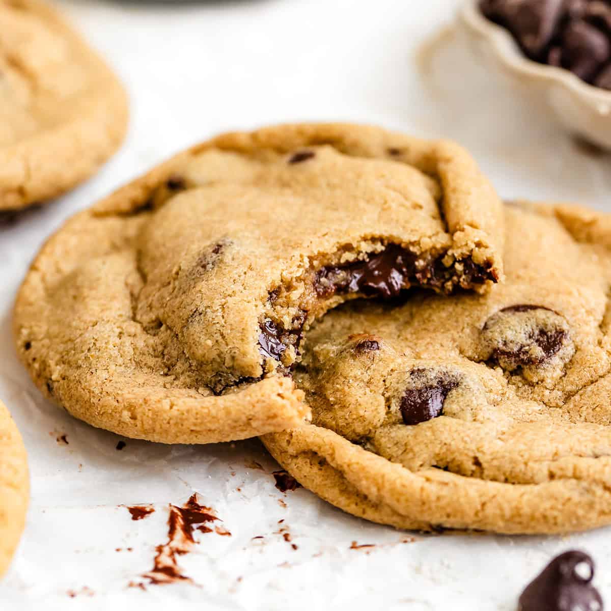 two Oat Flour Chocolate Chip Cookies, one with a bite taken out of it
