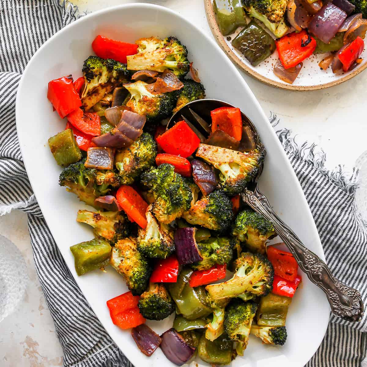 The best oven roasted vegetables recipe! Your favorite veggies are tossed in olive oil and a delicious spice mixture and are roasted until they are perfectly tender and slightly crispy. Baked vegetables are easy to make and a great way to meal prep vegetables for the week. overhead view of Oven Roasted Vegetables on a serving platter