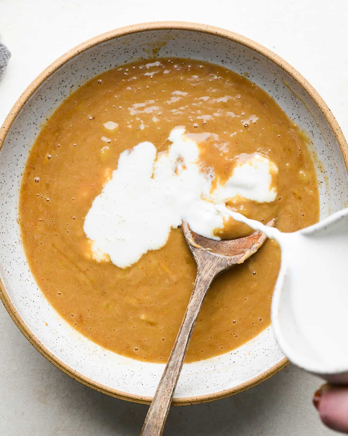 making peanut butter banana baked oatmeal, pouring milk into the batter before mixing