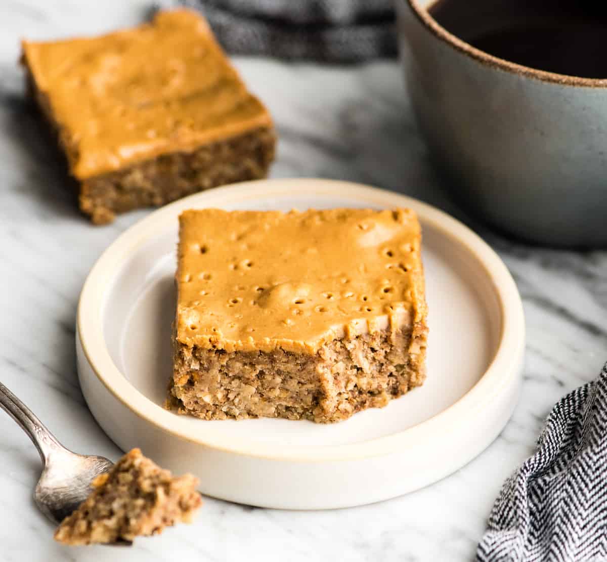 These are the BEST Healthy Breakfast Bars ever! I have eaten one every day for over a decade (seriously)! This easy recipe is made in one bowl in 30 minutes, and is loaded with fiber, protein & omega-3s to keep you full all morning long! Plus they’re gluten-free, dairy-free, refined sugar free and vegan! #breakfastbars #oatmeal #peanutbutter #glutenfree #dairyfree #vegan #healthy #refinedsugarfree a peanut butter breakfast bar on a plate with a bite taken out of it.
