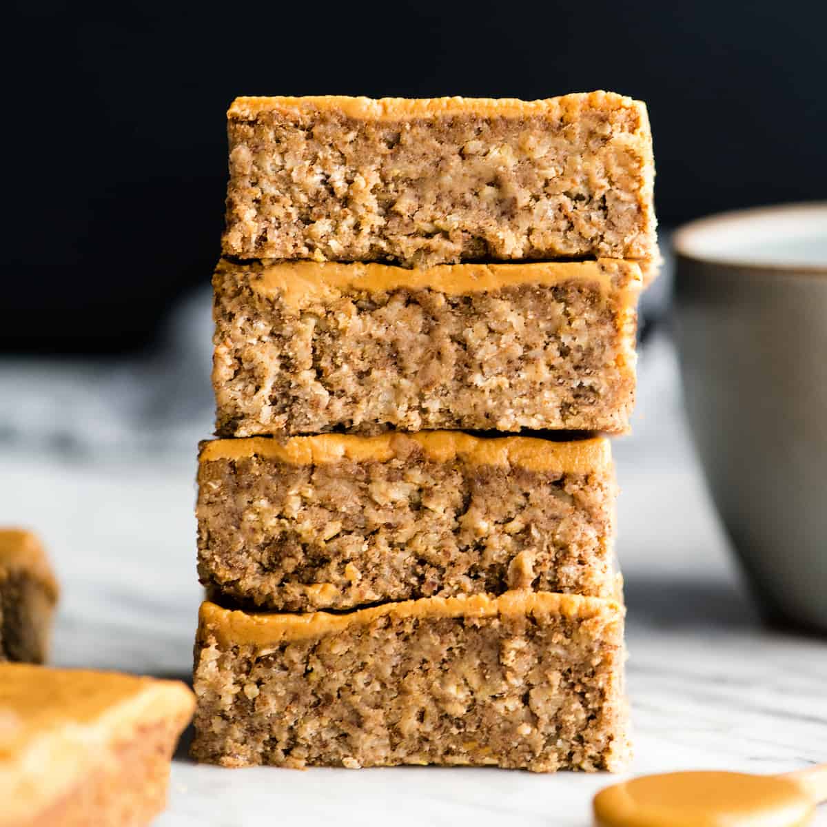 These are the BEST Healthy Breakfast Bars ever! I have eaten one every day for over a decade (seriously)! This easy recipe is made in one bowl in 30 minutes, and is loaded with fiber, protein & omega-3s to keep you full all morning long! Plus they’re gluten-free, dairy-free, refined sugar free and vegan! #breakfastbars #oatmeal #peanutbutter #glutenfree #dairyfree #vegan #healthy #refinedsugarfree front view of a stack of four healthy breakfast bars