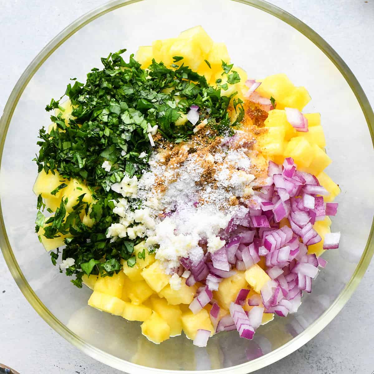 Pineapple Salsa ingredients in a glass mixing bowl