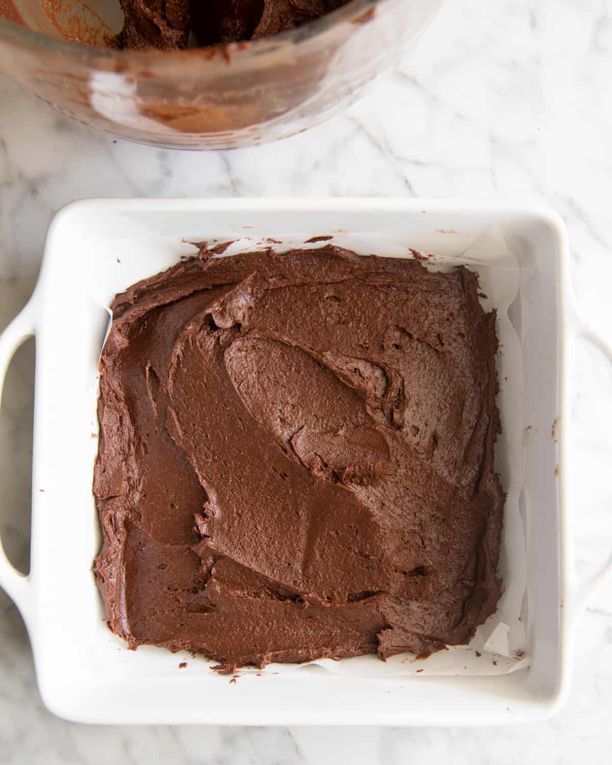 two-thirds of the brownie batter spread into the bottom of a baking dish