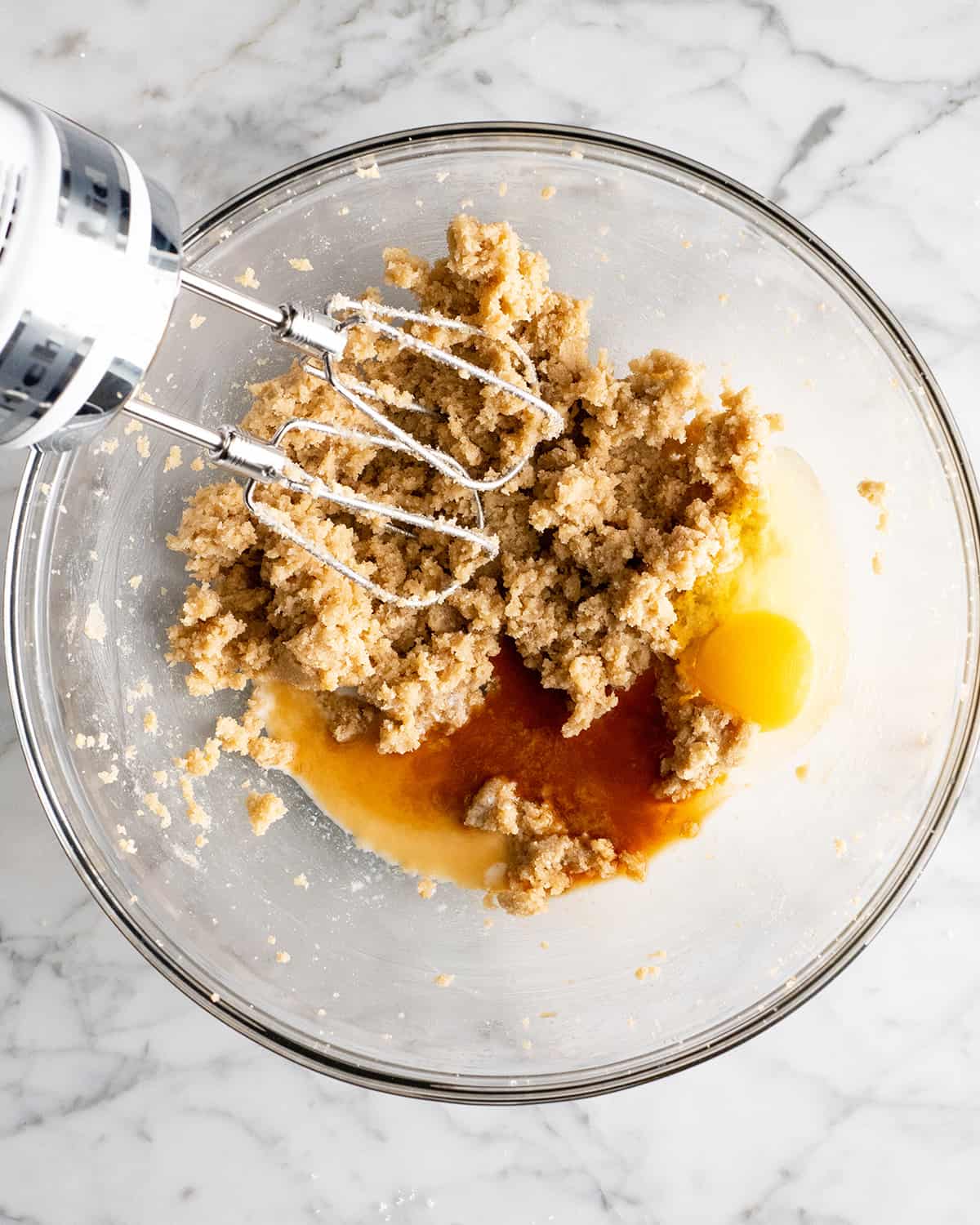 making a Chocolate Chip Skillet Cookie - adding vanilla, egg and milk before beating.