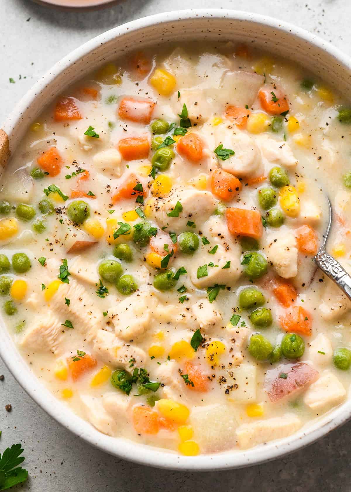 Chicken Pot Pie Soup in a bowl garnished with parsley and pepper