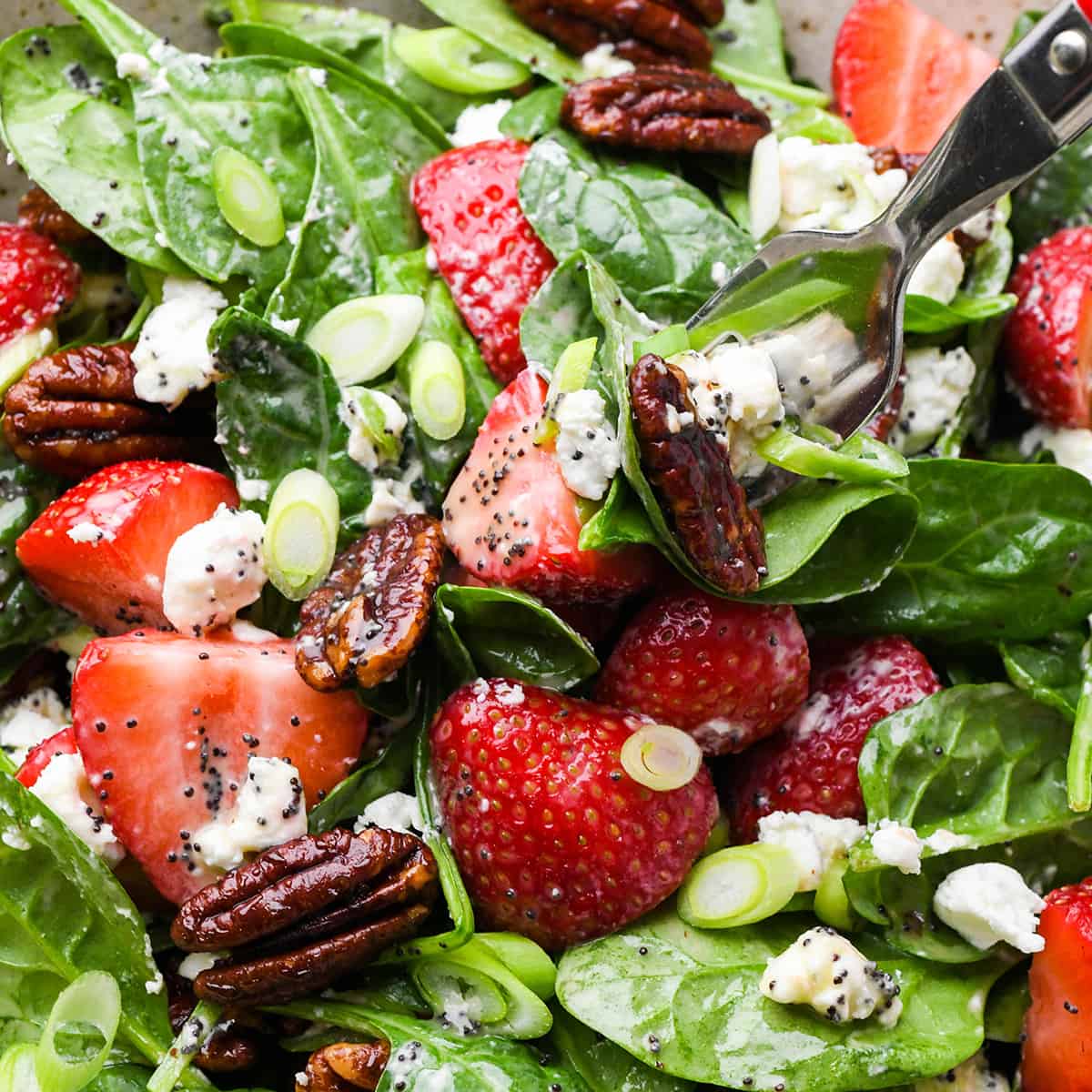 a fork taking a bite of Strawberry Spinach Salad