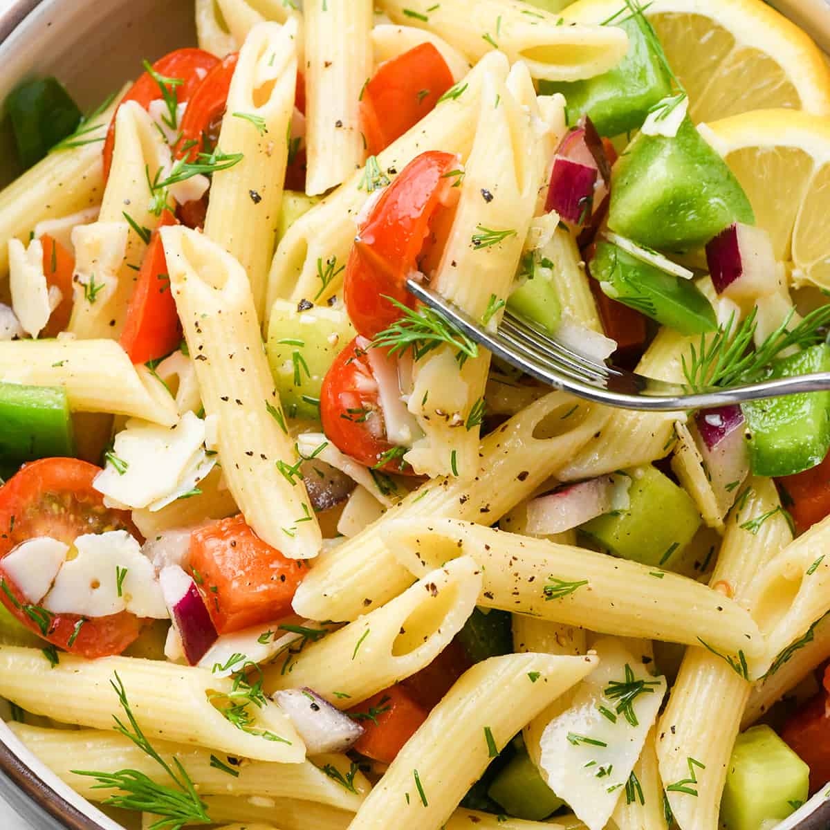a fork taking a bite of this lemon pasta salad