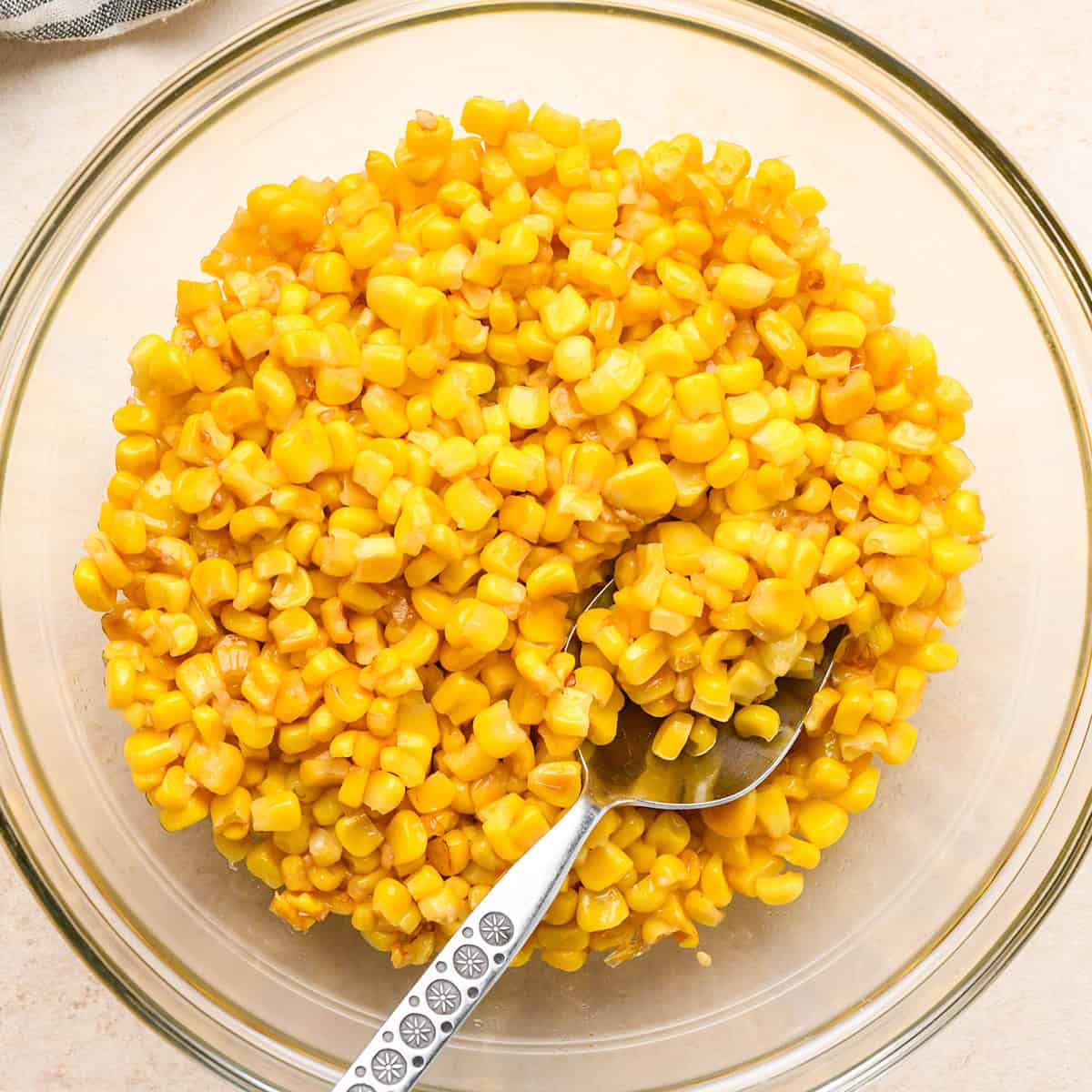 How to Make Corn Salsa - toasted corn cooling in a bowl with a spoon