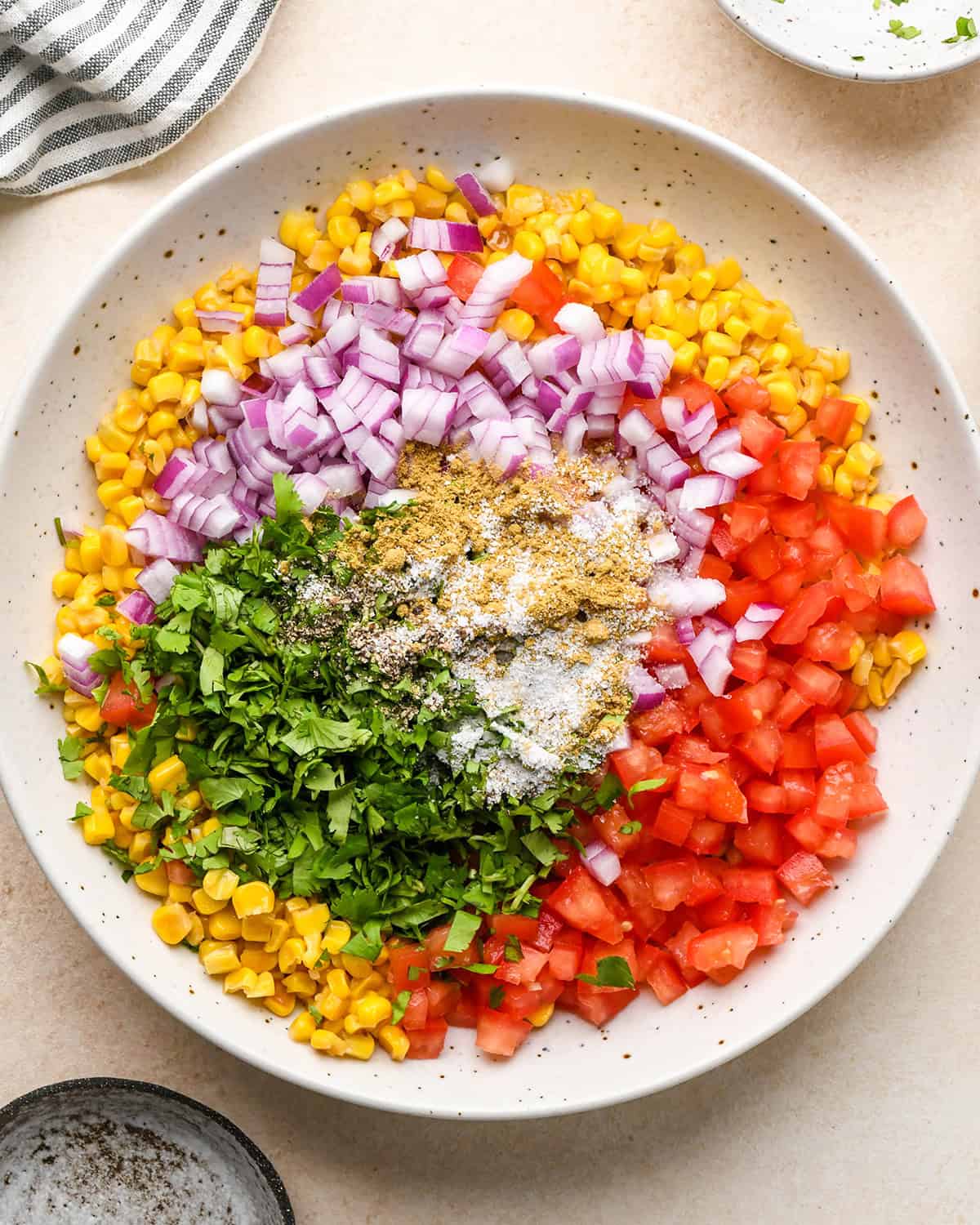 assembling corn salsa- ingredients in a bowl before mixing