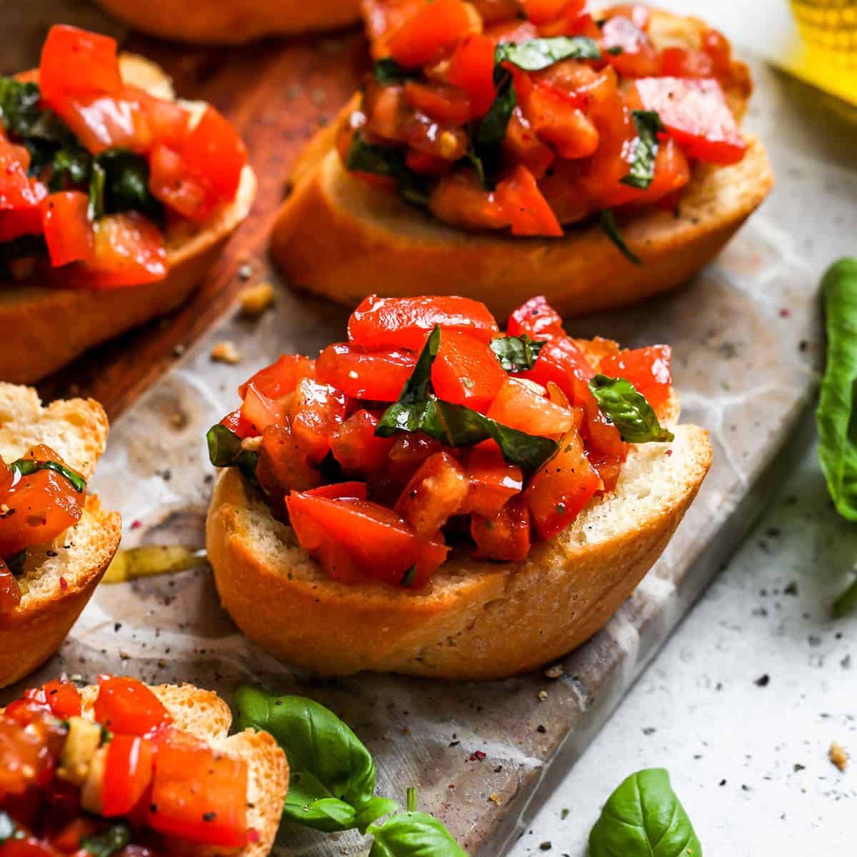 5 pieces of toasted bread topped with tomato bruschetta