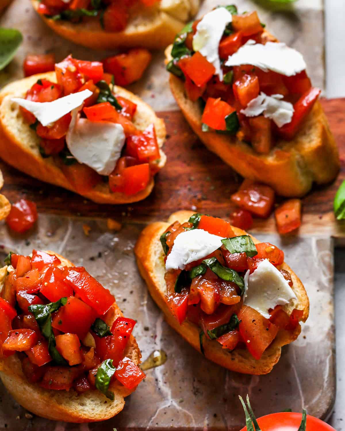 4 pieces of bread topped with tomato bruschetta recipe and mozzarella cheese