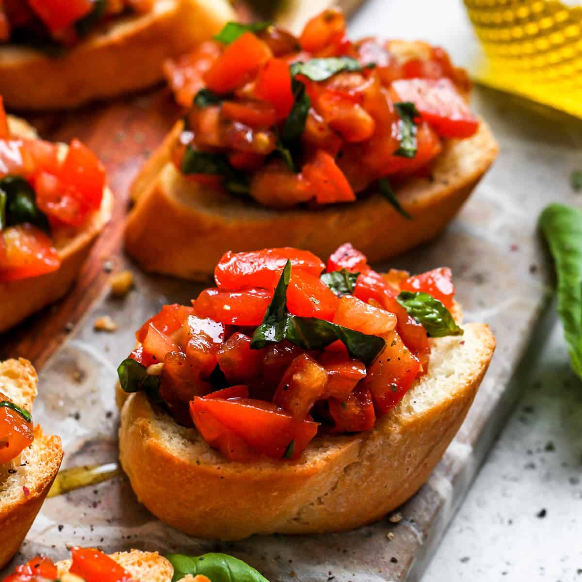 5 pieces of toasted bread topped with tomato bruschetta